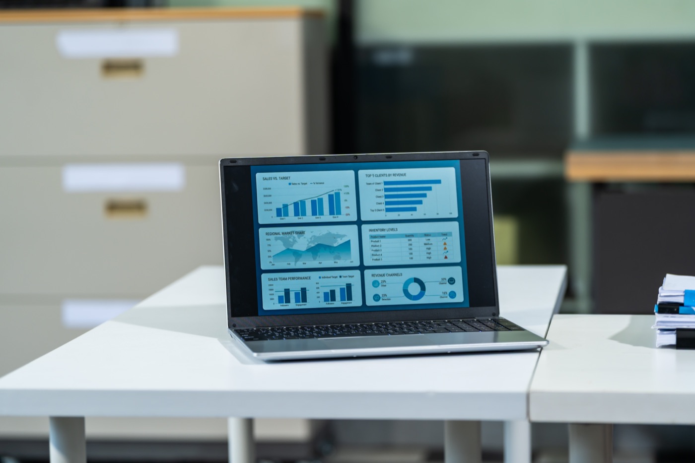 A laptop on a desk showing data dashboards